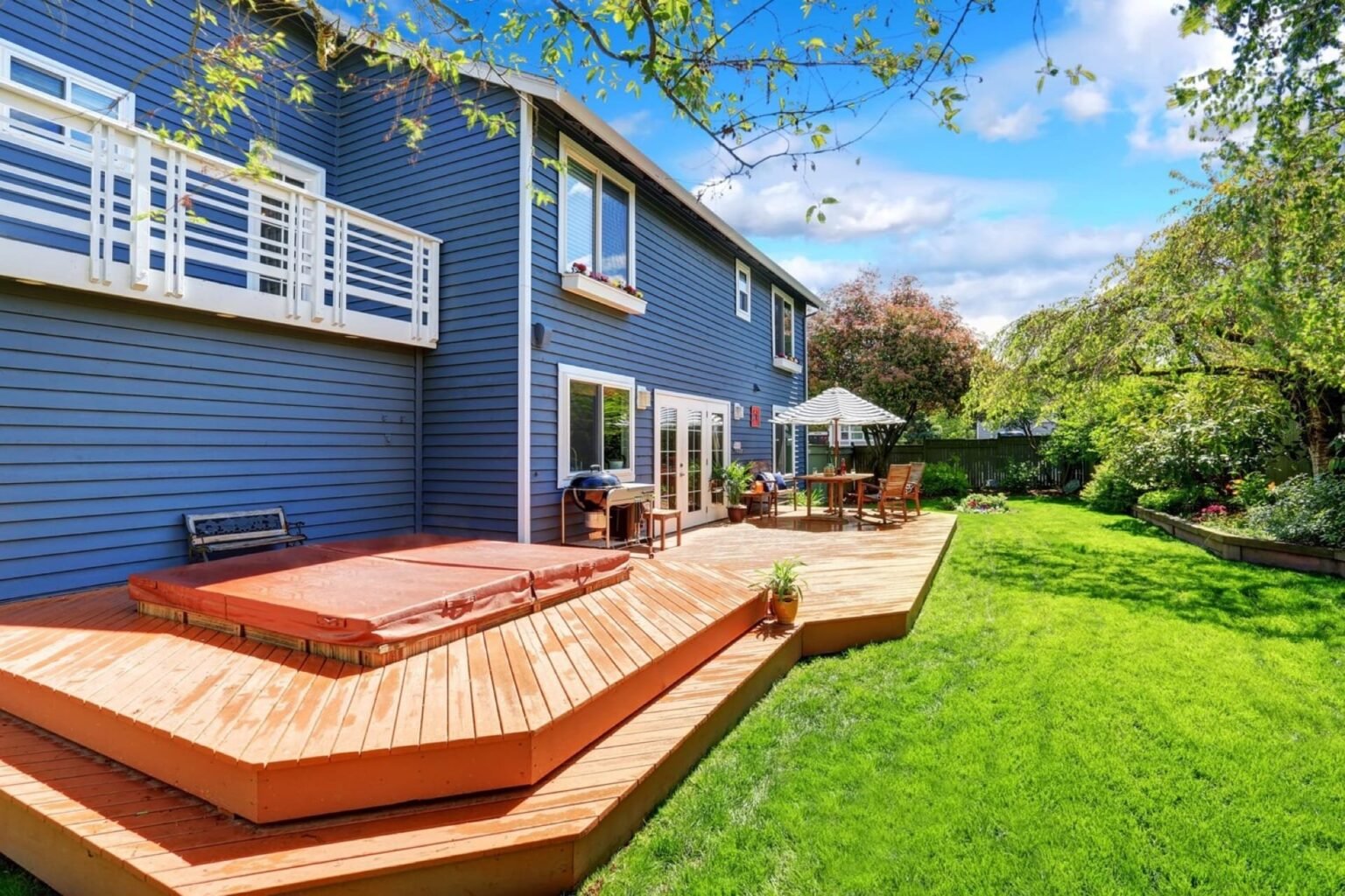 Perfect for large gatherings, this expansive cedar deck features multiple levels and built-in seating. The warm tones of the cedar are complemented by rich, red staining, integrating seamlessly with the home’s exterior and the lush backyard garden